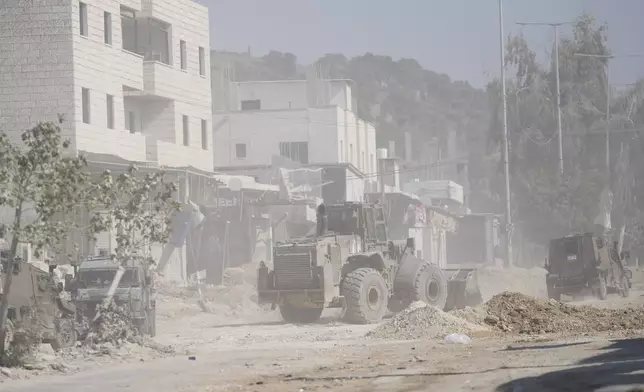 An Israeli army bulldozer operates at the parameter of the Nur Shams refugee camp during the ongoing army operation, after the Palestinian Health Ministry said two Palestinians were killed in an Israeli strike and a third by Israeli gunfire, in the West Bank city of Tulkarem, Thursday, Oct. 31, 2024. (AP Photo/Nasser Nasser)