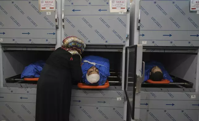 Relatives of Palestinian Husam Mallah, 28, center, Abdulaziz Abu al-Samen, 21, right and Ahmad Fahmawi, 19, in the morgue of a local hospital, as the Palestinian Health Ministry said two Palestinians were killed in an Israeli strike and a third by Israeli gunfire, in the West Bank city of Tulkarem Thursday, Oct. 31, 2024. (AP Photo/Nasser Nasser)