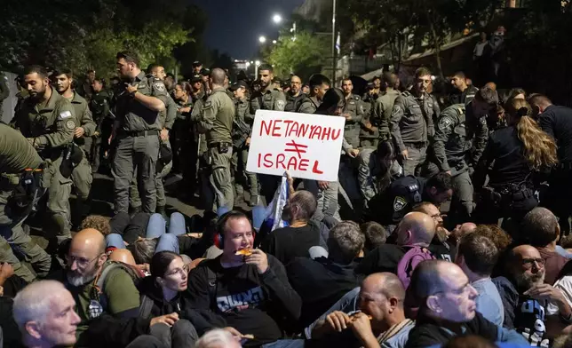 Police disperse people protesting against Prime Minister Benjamin Netanyahu's government and calling for the release of hostages held in the Gaza Strip by the Hamas militant group, near the Prime Minister's residence in Jerusalem, Monday, Oct. 28, 2024. (AP Photo/Ohad Zwigenberg)