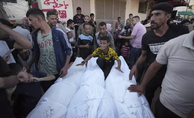 Mourners gather around bodies of Palestinians killed in the Israeli bombardment of the Gaza Strip, outside the hospital morgue in Deir al-Balah on Wednesday, Oct. 9, 2024. (AP Photo/Abdel Kareem Hana)