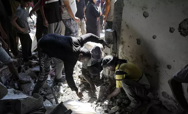 Palestinians search for the remains of their relatives killed in an Israeli bombardment of a school in Deir al-Balah, central Gaza Strip, Thursday, Oct. 10, 2024. (AP Photo/Abdel Kareem Hana)