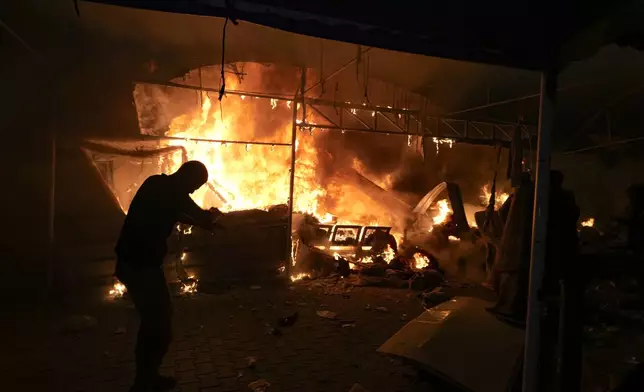 Palestinians react to a fire after an Israeli strike hit a tent area in the courtyard of Al Aqsa Martyrs hospital in Deir al Balah, Gaza Strip, Monday, Oct. 14, 2024. (AP Photo/Abdel Kareem Hana)