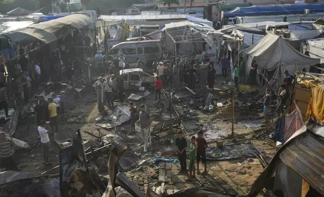 Palestinians look at the damage after an Israeli strike hit a tent area in the courtyard of Al Aqsa Martyrs hospital in Deir al Balah, Gaza Strip, Monday, Oct. 14, 2024. (AP Photo/Abdel Kareem Hana)