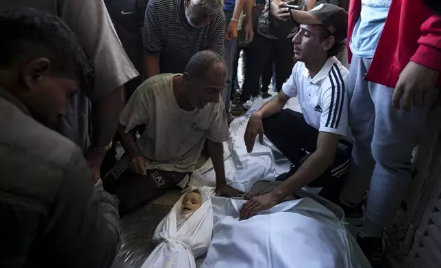 Palestinians mourn for relatives killed in the Israeli bombardment of the Gaza Strip at a hospital morgue in Deir al-Balah, Wednesday, Oct. 2, 2024. (AP Photo/Abdel Kareem Hana)