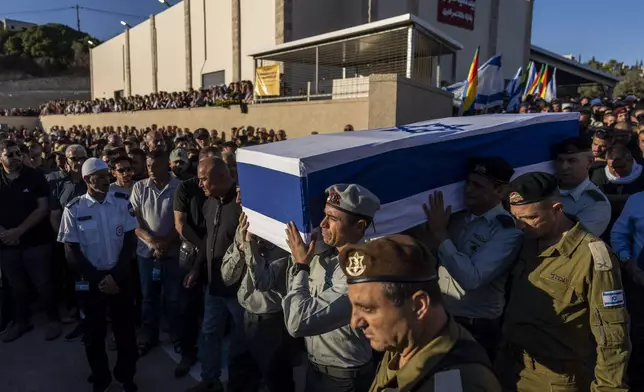 Israeli soldiers carry the flagged-covered coffin of Israeli Druze Colonel Ehsan Daxa, in Daliyat al-Carmel, Israel, Monday, Oct. 21, 2024. Daxa, 41, was killed during Israel's ground operation in the Gaza Strip, where the Israeli army has been battling Palestinian militants in the war ignited by Hamas' Oct. 7 2023 attack into Israel. (AP Photo/Ariel Schalit)