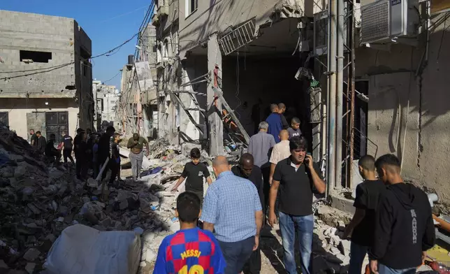 Palestinians examine the damage following an Israeli airstrike in the West Bank city of Tulkarem, which Palestinian health officials say killed 18 people and the Israeli military says took out a Hamas leader, on Friday, Oct. 4, 2024. (AP Photo/Nasser Nasser)