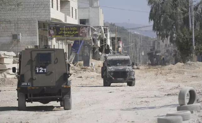 Israeli army units secure the parameter of the Nur Shams refugee camp during the ongoing army operation, after the Palestinian Health Ministry said two Palestinians were killed in an Israeli strike and a third by Israeli gunfire, in the West Bank city of Tulkarem Thursday, Oct. 31, 2024. (AP Photo/Nasser Nasser)