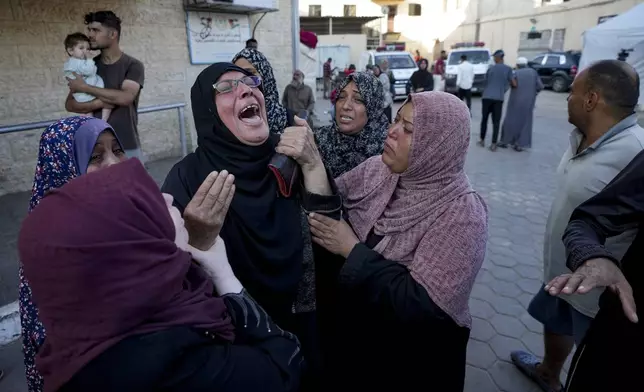 Palestinians mourn for relatives killed in the Israeli bombardment of the Gaza Strip at a hospital morgue in Deir al-Balah, Wednesday, Oct. 2, 2024. (AP Photo/Abdel Kareem Hana)