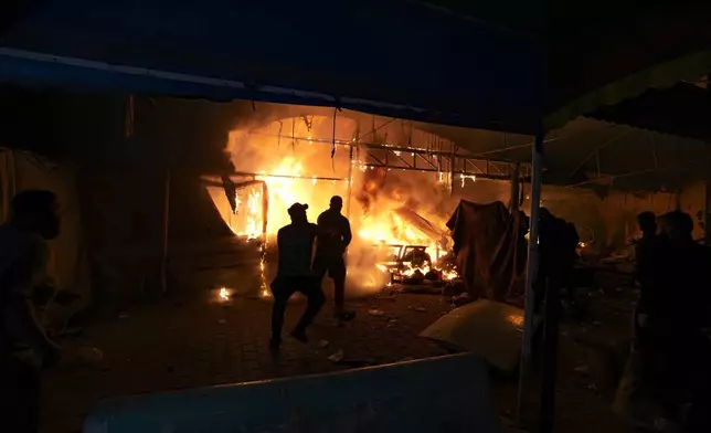 Palestinians react to a fire after an Israeli strike hit a tent area in the courtyard of Al Aqsa Martyrs hospital in Deir al Balah, Gaza Strip, Monday, Oct. 14, 2024. (AP Photo/Abdel Kareem Hana)