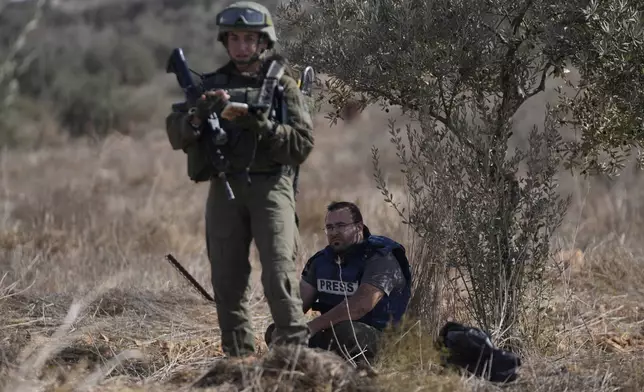 Israeli army troops temporarly detain Palestinian journalist Hesham Abu Shaqra, who was later released, while foreign activists and three European politicians joined the villagers on occasion of the Palestinian olive harvest season, and denied farmers access to their land in the West Bank town of Qusra, south of Nablus Tuesday, Oct. 29, 2024. (AP Photo/Nasser Nasser)