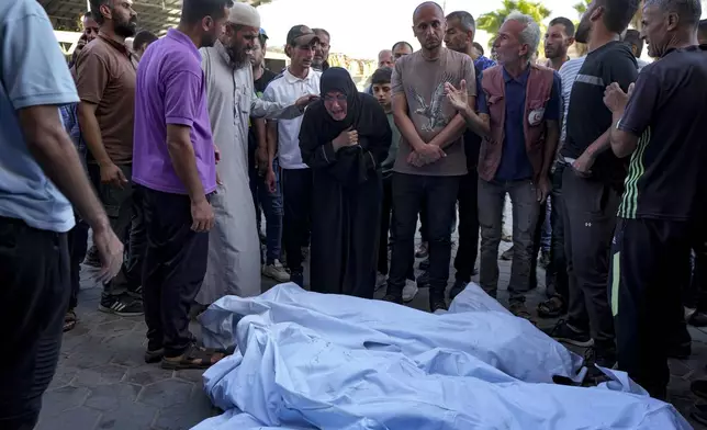 Palestinians mourn for relatives killed in the Israeli bombardment of the Gaza Strip at a hospital morgue in Deir al-Balah, Wednesday, Oct. 2, 2024. (AP Photo/Abdel Kareem Hana)