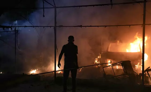 A Palestinian man reacts to a fire after an Israeli strike hit a tent area in the courtyard of Al Aqsa Martyrs hospital in Deir al Balah, Gaza Strip, Monday, Oct. 14, 2024. (AP Photo/Abdel Kareem Hana)