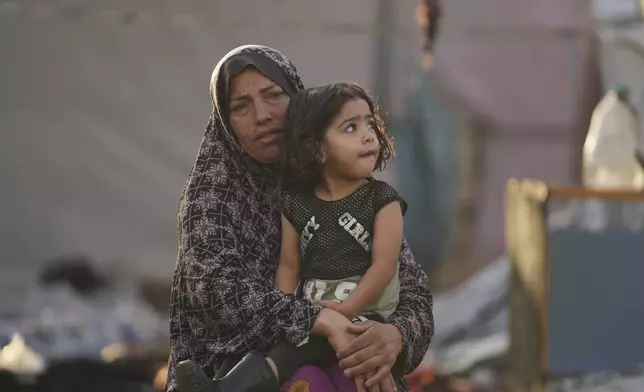 Palestinians look at the damage after an Israeli strike hit a tent area in the courtyard of Al Aqsa Martyrs hospital in Deir al Balah, Gaza Strip, Monday, Oct. 14, 2024. (AP Photo/Abdel Kareem Hana)