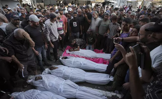 Mourners gather around the bodies of Palestinian men who were killed in an Israeli airstrike in Deir al-Balah, Gaza, Sunday, Oct. 6, 2024. (AP Photo/Abdel Kareem Hana)