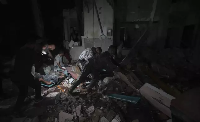 Palestinians search for survivors and bodies in the rubble of a mosque destroyed in an Israeli airstrike in Deir al-Balah, Sunday, Oct. 6, 2024. (AP Photo/Abdel Kareem Hana)