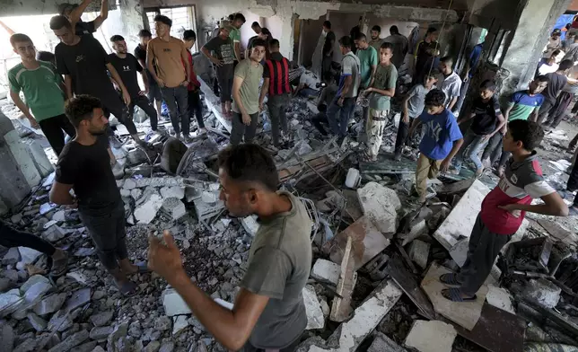 Palestinians search for the bodies of their relatives killed in an Israeli bombardment of a school in Deir al-Balah, central Gaza Strip, Thursday, Oct. 10, 2024. (AP Photo/Abdel Kareem Hana)