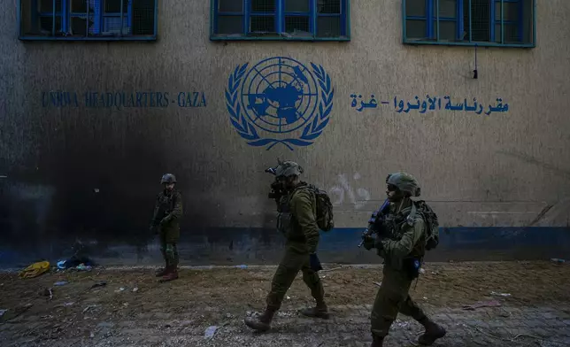 FILE - Israeli soldiers take position as they enter the UNRWA headquarter where the military discovered tunnels underneath of the U.N. agency that the military says Hamas militants used to attack its forces during a ground operation in Gaza, Thursday, Feb. 8, 2024. (AP Photo/Ariel Schalit, File)