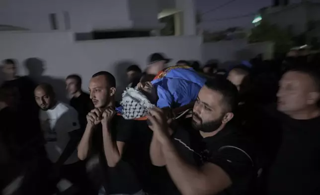 Mourners carry the body of Sameer A'mar, 55, during his funeral in the West Bank town of Shuweika, north of Tulkarem, Tuesday, Sept. 17, 2024. A'mar was shot dead by Israel forces near the separation barrier in mid-September according to Wafa, the official Palestinian news agency. (AP Photo/Majdi Mohammed)