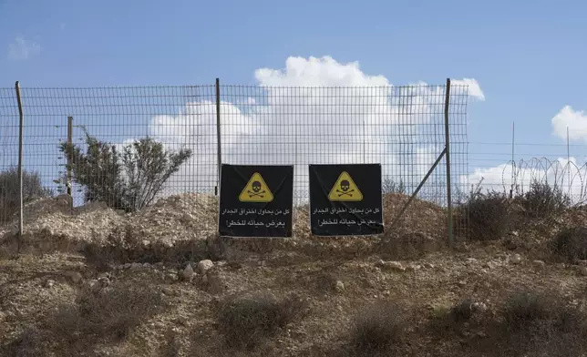 A section of the separation barrier with a warning sign that reads "any one who attempts to break through the barrier will put his life in danger," at the outskirts of the West Bank city of Dhahiriya Wednesday, Sept. 18, 2024. (AP Photo/Mahmoud Illean)