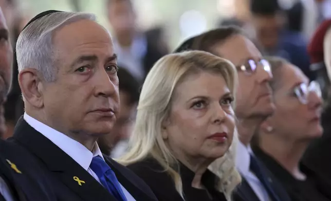 Israel's Prime Minister Benjamin Netanyahu, from left, his wife Sara Netanyahu, President Isaac Herzog and First Lady Michal Herzog, attend a ceremony marking the Hebrew calendar anniversary of the Hamas attack on October 7 last year that sparked the ongoing war in Gaza, at the Mount Herzl military cemetery in Jerusalem, Israel Sunday Oct. 27, 2024. (Gil Cohen-Magen/Pool Photo via AP)