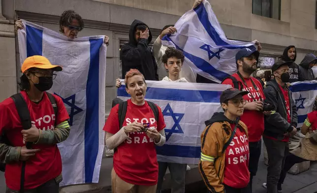 Pro-Israel protesters holds Israeli flags as demonstrators protest Israel's war against Hamas outside the New York Stock Exchange, Monday, Oct. 14, 2024, in New York. (AP Photo/Yuki Iwamura)