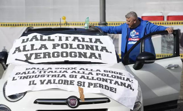 A banner reading "From Italy to Poland, shame!" is placed on a car during a demonstration of workers of automotive sector in Rome's Piazza Del Popolo Square on the occasion of their national strike, Friday, Oct. 18, 2024. (AP Photo/Gregorio Borgia)