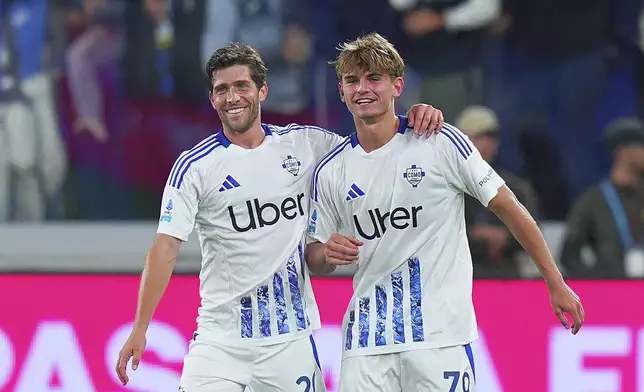 Como's Nico Paz, right, and Sergi Roberto celebrate after Paz scored during the Serie A soccer match between Atalanta and Como at the Gewiss Stadium in Bergamo, Italy, Tuesday, Sept. 24 , 2024. (Spada/LaPresse via AP)