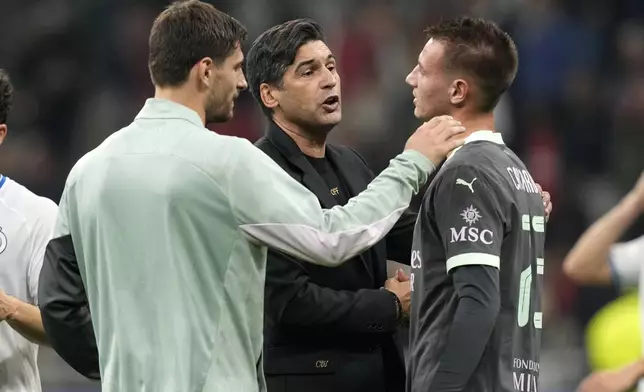 AC Milan's head coach Paulo Fonseca, center, talks to Francesco Camarda after the Champions League opening phase soccer match between AC Milan and Club Brugge at the San Siro stadium in Milan, Italy, Tuesday, Oct. 22, 2024. (AP Photo/Antonio Calani)