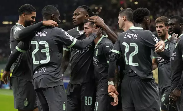 AC Milan's Christian Pulisic, center, celebrates with teammates after scoring his side's first goal during the Champions League opening phase soccer match between AC Milan and Club Brugge at the San Siro stadium in Milan, Italy, Tuesday, Oct. 22, 2024. (AP Photo/Antonio Calani)