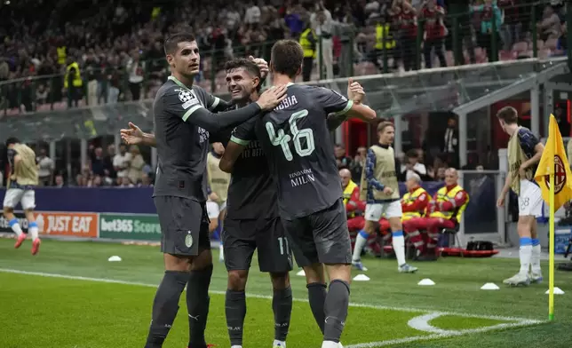 AC Milan's Christian Pulisic, center, celebrates with teammates after scoring his side's first goal during the Champions League opening phase soccer match between AC Milan and Club Brugge at the San Siro stadium in Milan, Italy, Tuesday, Oct. 22, 2024. (AP Photo/Antonio Calani)