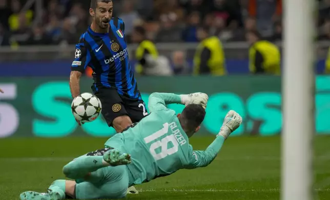 Red Star's goalkeeper Omri Glazer, front, makes a save in front of Inter Milan's Henrikh Mkhitaryan during the Champions League opening phase soccer match between Inter Milan and Red Star, at the San Siro stadium in Milan, Italy, Tuesday, Oct. 1, 2024. (AP Photo/Luca Bruno)