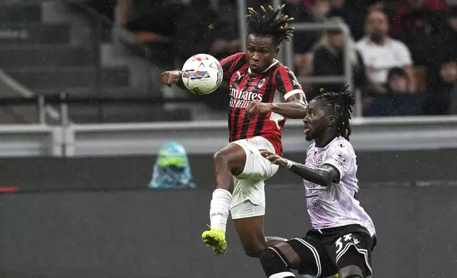 AC Milan's Samuel Chukwueze, left, and Udinese's Jordan Zemura challenge for the ball during the Serie A soccer match between AC Milan and Udinese at the San Siro Stadium, in Milan, Italy, Saturday, Oct. 19, 2024. (AP Photo/Antonio Calanni)