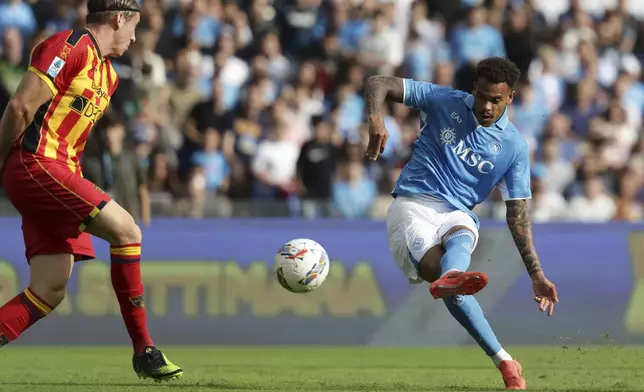 Napoli's Cyril Ngonge, right, shoots the ball during the Serie A soccer match between Napoli and Lecce at the Diego Armando Maradona Stadium in Naples, Italy, Saturday, Oct. 26, 2024. (Alessandro Garofalo/LaPresse via AP)