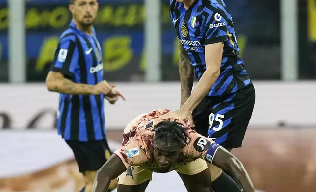 Inter Milan's Alessandro Bastoni, top, heads the ball over Torino's Duvan Zapata during the Serie A soccer match between Inter Milan and Torino at the San Siro Stadium, in Milan, Italy, Saturday, Oct. 5, 2024. (AP Photo/Antonio Calanni)