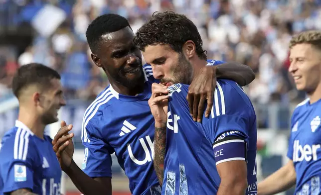 Como's Patrick Cutrone kisses the jersey as he celebrates scoring during a Serie A soccer match between Como and Verona at the Giuseppe Sinigaglia stadium in Como, northern Italy, Sunday, Sept. 29, 2024.(Antonio Saia/LaPresse via AP)