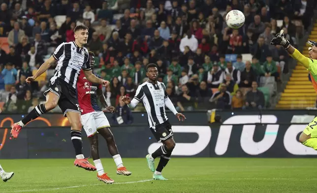 Udinese's Lorenzo Lucca, left, heads the ball to score their side's first goal of the game during the Serie A soccer match between Udinese and Cagliari at the Bluenergy Stadium in Udine, Italy, Friday, Oct. 25, 2024. (Andrea Bressanutti/LaPresse via AP)