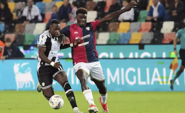 Udinese's Hassane Kamara fights for the ball with Cagliari's Michel Adopo, right, during the Serie A soccer match between Udinese and Cagliari at the Bluenergy Stadium in Udine, Italy, Friday, Oct. 25, 2024. (Andrea Bressanutti/LaPresse via AP)