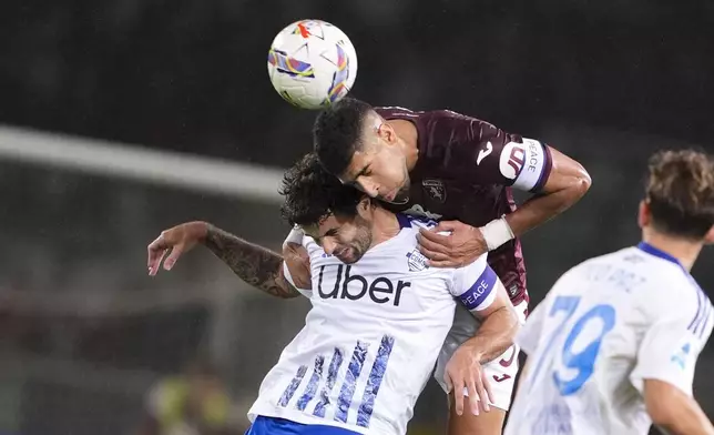 Torino's Adam Masina, top, fights for the ball with Como's Patrick Cutrone during the Serie A soccer match between Torino FC and Como at the Stadio Olimpico Grande Torino in Turin, Italy,Oct. 25, 2024. (Fabio Ferrari/LaPresse via AP)