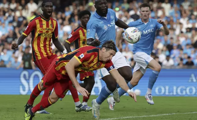 Napoli's Romelu Lukaku, centre, and Lecce's Federico Baschirotto, bottom, challenge for the ball during the Serie A soccer match between Napoli and Lecce at the Diego Armando Maradona Stadium in Naples, Italy, Saturday, Oct. 26, 2024. (Alessandro Garofalo/LaPresse via AP)