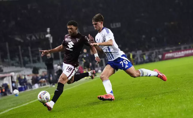 Torino's Che Adams, left, fights for the ball with Como's Nico Paz during the Serie A soccer match between Torino FC and Como at the Stadio Olimpico Grande Torino in Turin, Italy,Oct. 25, 2024. (Fabio Ferrari/LaPresse via AP)