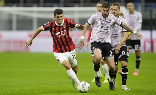 AC Milan's Christian Pulisic, left, and Udinese's Iker Bravo challenge for the ball during the Serie A soccer match between AC Milan and Udinese at the San Siro Stadium, in Milan, Italy, Saturday, Oct. 19, 2024. (AP Photo/Antonio Calanni)