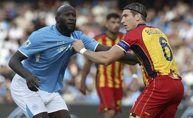 Napoli's Romelu Lukaku, left, and Lecce's Federico Baschirotto challenge for the ball during the Serie A soccer match between Napoli and Lecce at the Diego Armando Maradona Stadium in Naples, Italy, Saturday, Oct. 26, 2024. (Alessandro Garofalo/LaPresse via AP)