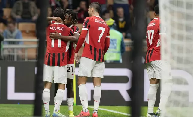 AC Milan's Samuel Chukwueze, second from left, celebrates with Christian Pulisic, left, after scoring the opening goal during the Serie A soccer match between AC Milan and Udinese at the San Siro Stadium, in Milan, Italy, Saturday, Oct. 19, 2024. (AP Photo/Antonio Calanni)