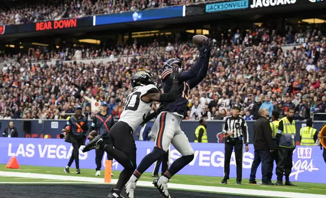 Chicago Bears wide receiver Keenan Allen (13), right, catches the ball to score a touchdown during the fourth quarter of an NFL football game at the Tottenham Hotspur stadium between the Jacksonville Jaguars and Chicago Bears in London, Sunday, Oct. 13, 2024. (AP Photo/Steve Luciano)