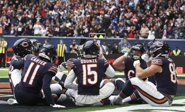 Bears players celebrate after Chicago Bears wide receiver Keenan Allen (13) scored his side's third touchdown during the third quarter of an NFL football game at the Tottenham Hotspur stadium between the Jacksonville Jaguars and Chicago Bears in London, Sunday, Oct. 13, 2024. (AP Photo/Ian Walton)