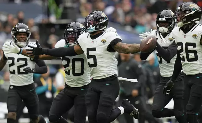 Jacksonville Jaguars safety Andre Cisco (5) celebrates making an interception during an NFL football game at the Tottenham Hotspur stadium between the Jacksonville Jaguars and Chicago Bears in London, Sunday, Oct. 13, 2024. (AP Photo/Steve Luciano)