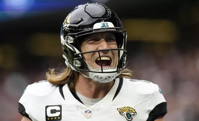 Jacksonville Jaguars quarterback Trevor Lawrence (16) celebrates after Jaguars wide receiver Gabe Davis (0) scored a touchdown in the fourth quarter of an NFL football game at the Tottenham Hotspur stadium between the Jacksonville Jaguars and Chicago Bears in London, Sunday, Oct. 13, 2024. (AP Photo/Steve Luciano)