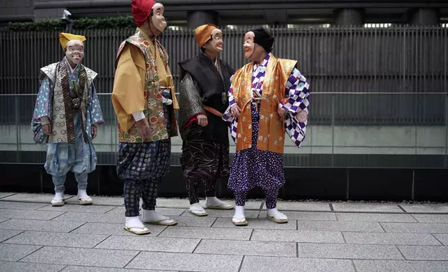 Artists wearing traditional clown masks prepare to march during the annual Shinto festival called the Grand Festival at the Kotohiragu shrine in the Toranomon business district of Tokyo, Thursday, Oct. 10, 2024. (AP Photo/Eugene Hoshiko)