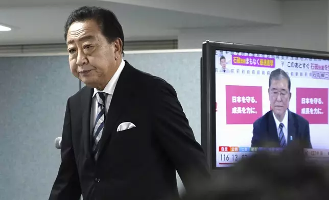 Yoshihiko Noda, leader of Japan's opposition Constitutional Democratic Party, prepares for a media interview with Japan's Prime Minister and president of the Liberal Democratic Party (LDP) Shigeru Ishiba seen on TV screen, at Noda’s party headquarters Sunday, Oct. 27, 2024 in Tokyo, (Kyodo News via AP)