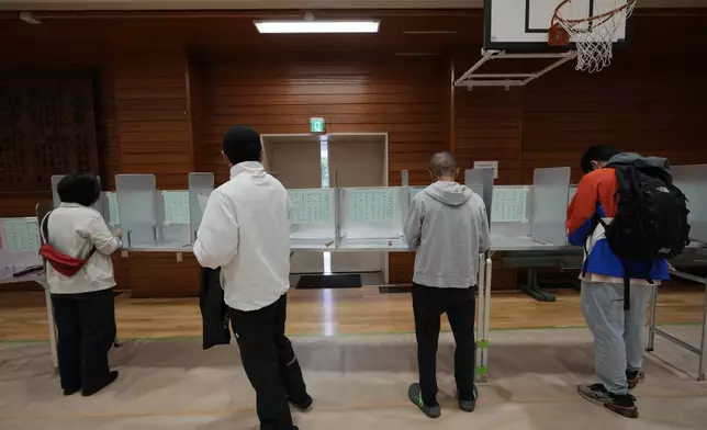 Voters prepare to cast their ballots at a polling station for Japan's lower house election in Tokyo, Japan, Sunday, Oct. 27, 2024. (AP Photo/Hiro Komae)